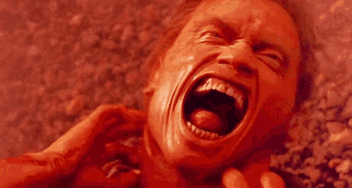 a close up of a man 's face with his mouth open and his tongue sticking out