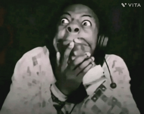 A streamer in black and white covers his mouth with wide alarmed eyes.