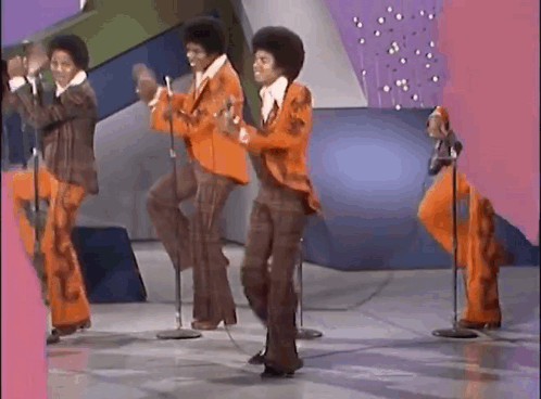 The Jackson 5 perform synchronized dance moves on a colorful stage.