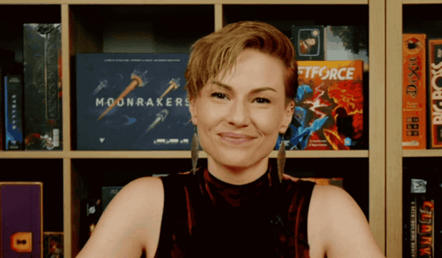 a woman stands in front of a bookshelf with a book called moonrakers