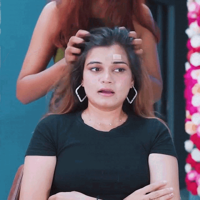 a woman with a bandage on her forehead has a black shirt on