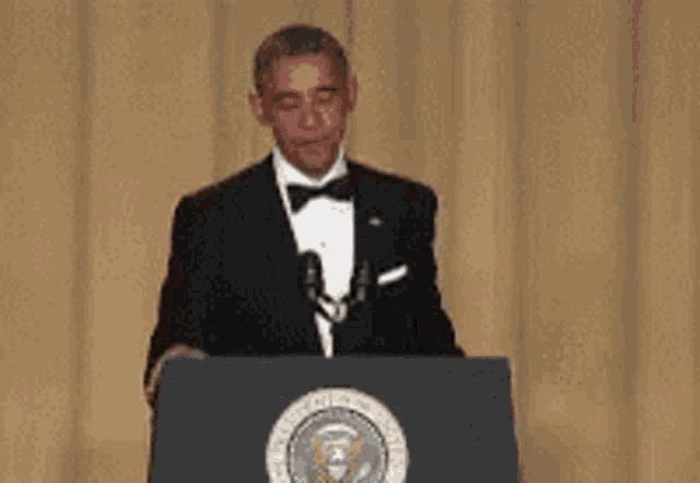 Barack Obama stands at a podium in a tuxedo, ready to finish his remarks.