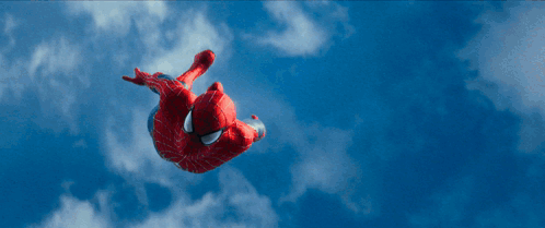 a spider man is flying through a blue sky with clouds
