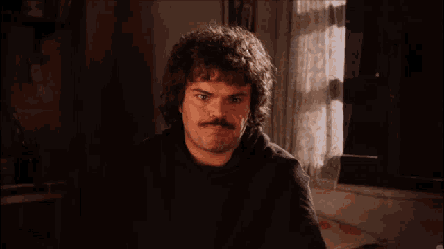 Jack Black as Nacho Libre looks over with a puzzled expression.