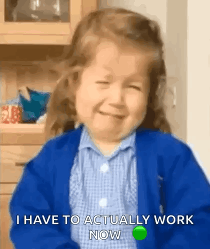 a little girl is crying and smiling while wearing a blue sweater .