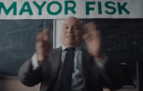 a man in a suit and tie stands in front of a banner that says mayor fisk
