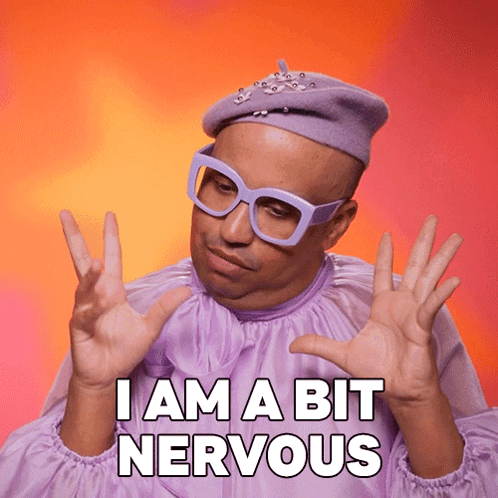 A person in lavender drag attire raises both hands beside the caption “I AM A BIT NERVOUS.”