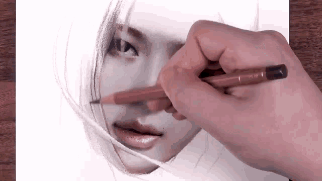 a close up of a person drawing a woman 's face with a pencil