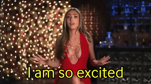 a woman in a red dress says i am so excited in front of christmas lights