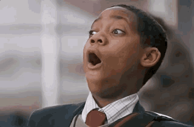 A school-uniformed boy opens his mouth wide in surprise.