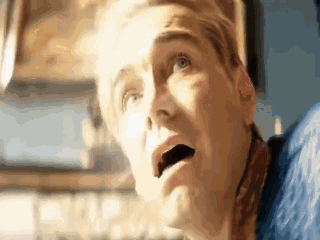 a close up of a person 's face with a surprised look on their face .