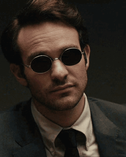 a man wearing sunglasses and a suit and tie