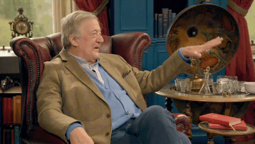 a man sitting in a chair with his arm outstretched pointing at something
