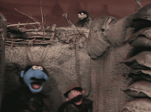 two sesame street puppets standing next to each other in a dark room