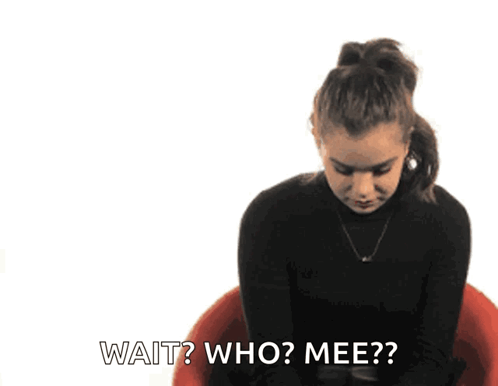 a woman in a black turtleneck is sitting in a red chair and says wait who mee ?