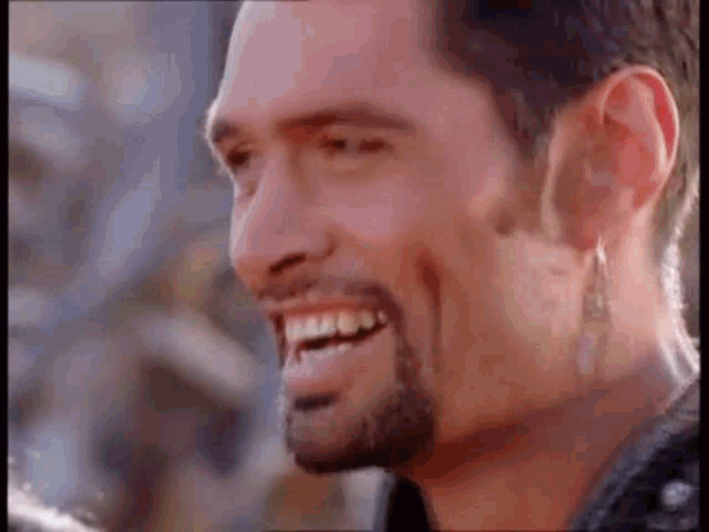 a man with a beard is smiling and looking at the camera