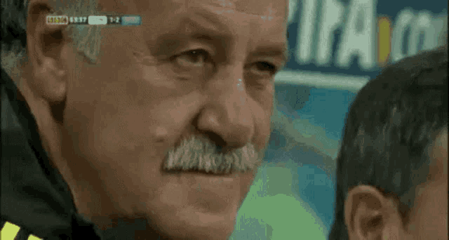 An older man gives a stern, unimpressed look in a close-up.