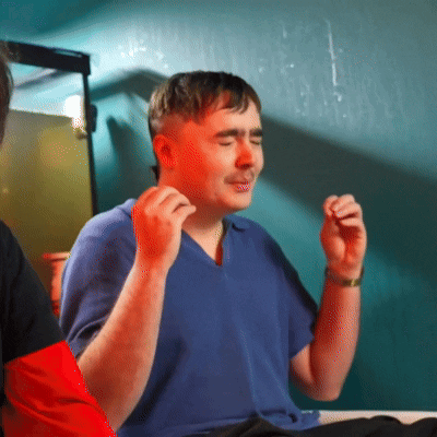 a man wearing a blue shirt is sitting at a table with his eyes closed