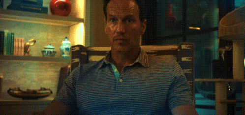 a man in a blue and white striped shirt sitting in a chair