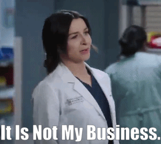 a woman in a lab coat is standing in front of a sign that says it is not my business .