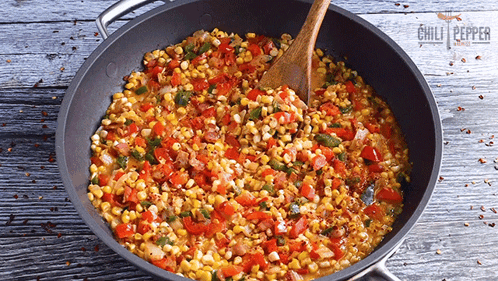 a pan of corn and vegetables with a wooden spoon in it and the words chili peppers on the bottom