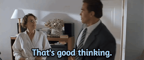 a man and a woman are sitting at a table and the woman says that 's good thinking