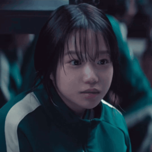 a girl in a green jacket with white stripes on the side
