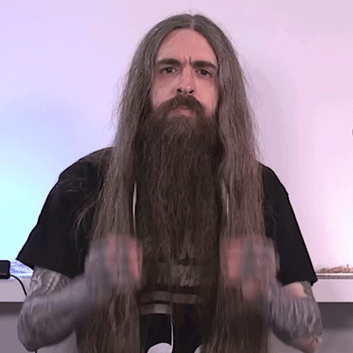 a man with long hair and a beard is wearing a black shirt that says nirvana on it