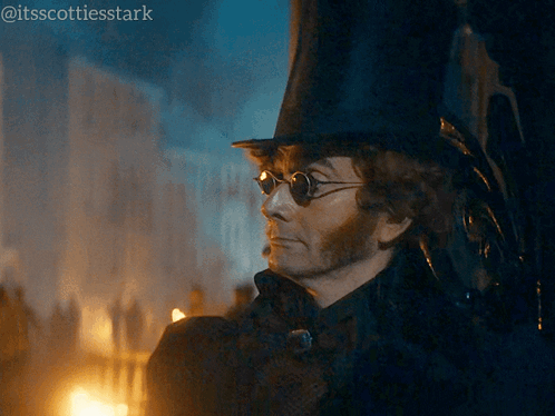 a man wearing a top hat and sunglasses is standing in front of a building ..