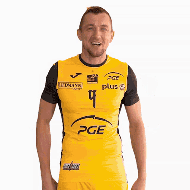 a man wearing a yellow shirt with pge plus on it