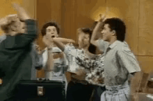 Friends around a diner table celebrate with high fives.