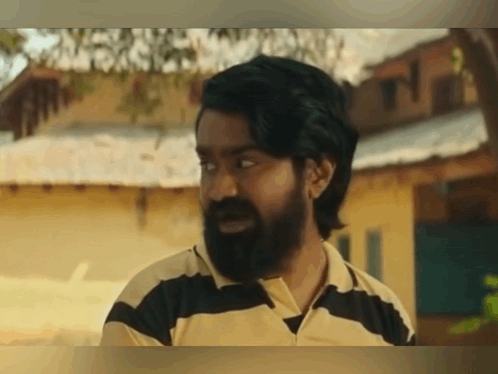 a man with a beard wearing a black and yellow striped shirt