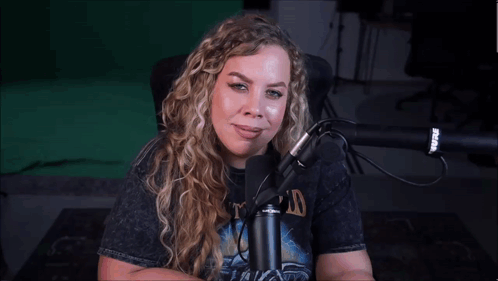 a woman sitting in front of a microphone wearing a shirt that says ' nirvana ' on it