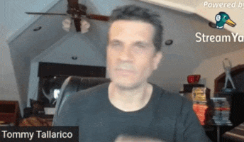 tommy tallarico is sitting in front of a camera
