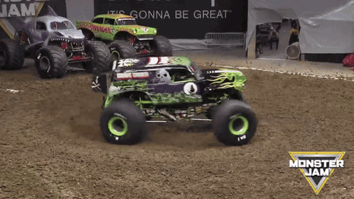 three monster jam trucks are racing in a dirt track
