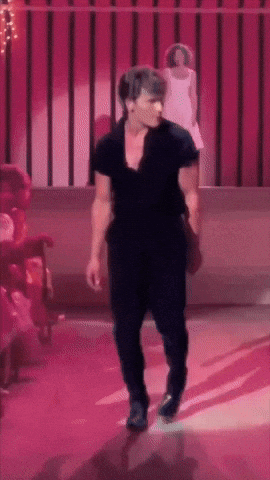 a man in a black shirt and black pants is dancing on a stage