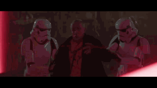 a stormtrooper is holding a red lightsaber in his hand .