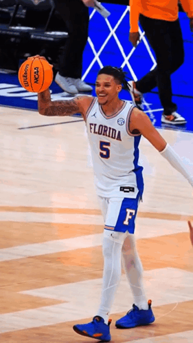 a florida basketball player holds an orange wilson basketball