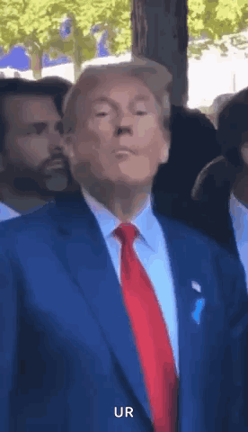 Donald Trump points forward and gives a thumbs-up outdoors.