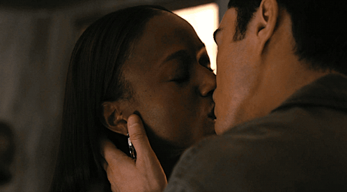 a man and a woman are kissing and the man is holding the woman 's hand