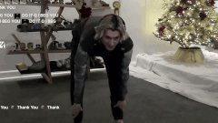 a man is doing a stretching exercise in front of a christmas tree ..