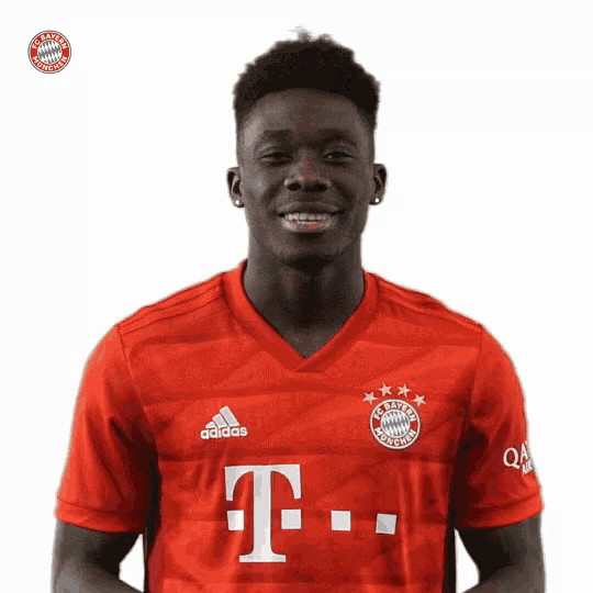a man wearing a red adidas shirt with a white t on it
