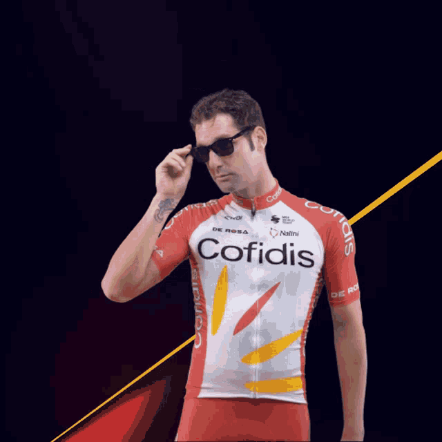 a man is wearing sunglasses and a red and white cofidis jersey