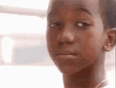 A boy looks away sadly with a single tear in his eye.