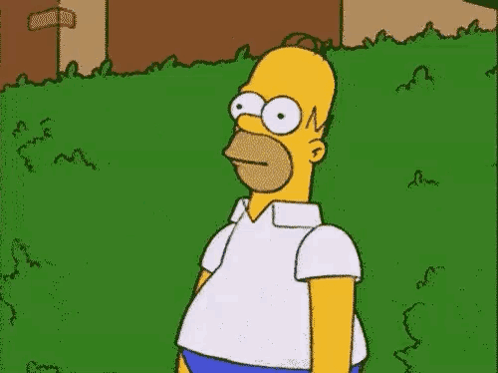 Homer Simpson stands partly hidden behind a hedge.