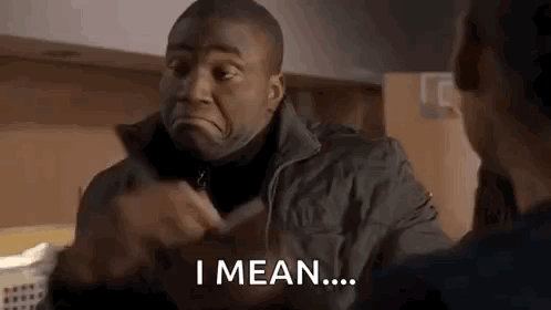 Dean Miller from Station 19 gestures while speaking in a dim indoor scene.
