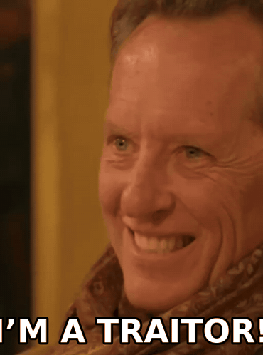 a man is smiling with the words " i 'm a traitor " behind him