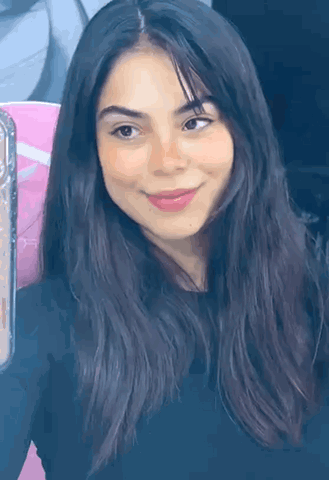 A woman in a vertical selfie clip gives a subtle wink.