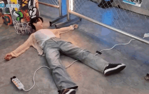 a person is laying on the floor with a remote control in their hand .