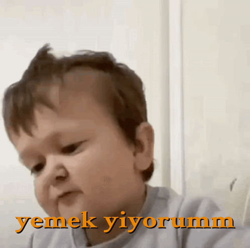 a baby making a funny face with the words yemek yiyorum in the upper right corner